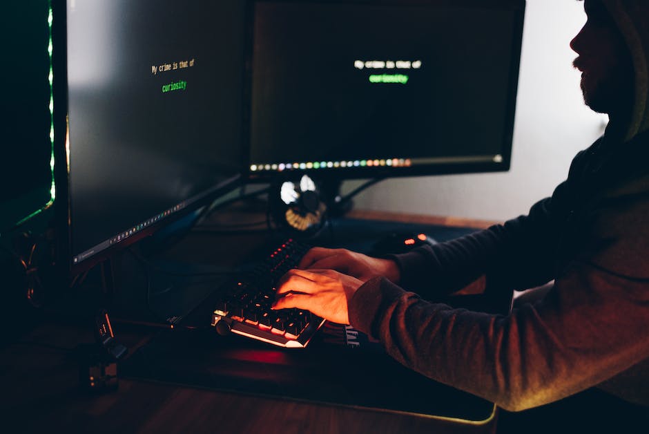 over shoulder view of keyboard and monitors